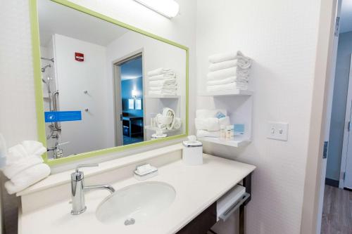 a bathroom with a sink and a large mirror at Hampton Inn Bismarck in Bismarck