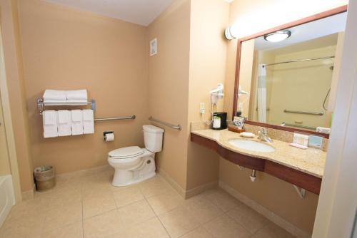 a bathroom with a toilet and a sink and a mirror at Hampton Inn Bismarck in Bismarck