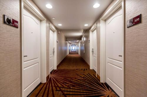 a hallway with white doors and a rug at Hampton Inn Bismarck in Bismarck