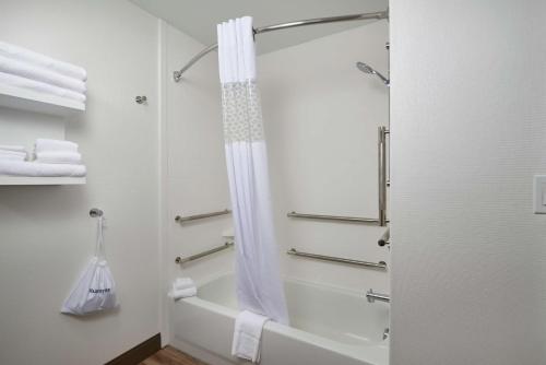 海倫娜的住宿－海倫娜漢普頓酒店，浴室配有淋浴帘和浴缸。