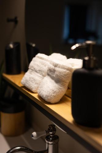 a pile of white towels sitting on a shelf at Les Chambres de Sonia et Éric in Couvains