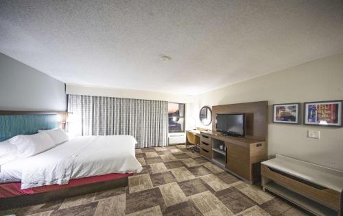 a hotel room with a bed and a television at Hampton Inn Hutchinson in Hutchinson