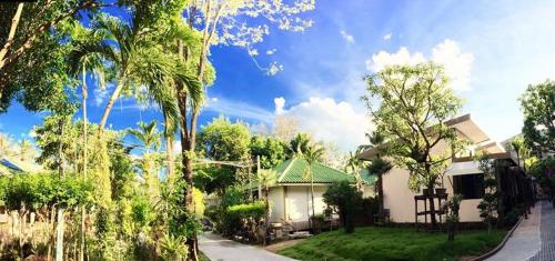 a house with a green roof in a yard at Lamai Inn 99 Bungalows in Lamai