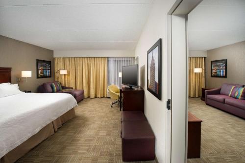 una camera d'albergo con letto e divano di Hampton Inn Rochester Greece a Rochester