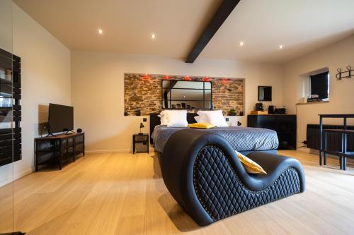 a bedroom with a bed and a stone wall at Les Chambres de Sonia et Éric in Couvains