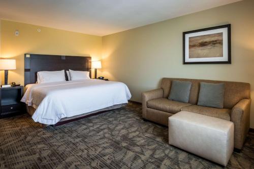 Habitación de hotel con cama y silla en Hampton Inn Indianapolis NW/Zionsville, en Whitestown