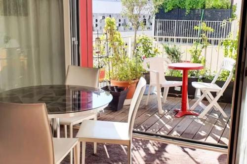 a patio with a table and chairs on a deck at OG 2024 with parking option Eiffel seightseing in Paris