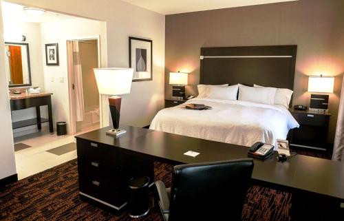 a bedroom with a bed and a desk with a telephone at Hampton Inn & Suites Tulsa/Tulsa Hills in Tulsa