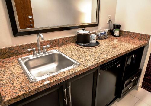 a kitchen counter with a sink and a mirror at Hampton Inn & Suites Tulsa/Tulsa Hills in Tulsa