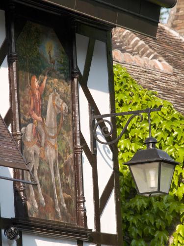a painting on the side of a building with a lamp at Hôtellerie Du Bas-Bréau in Barbizon