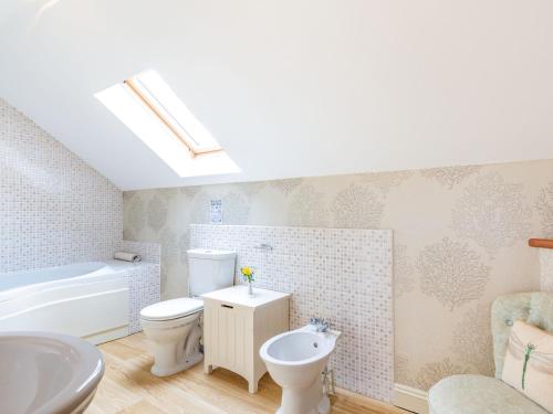 a bathroom with a toilet and a sink and a tub at The Hayloft in Lostwithiel