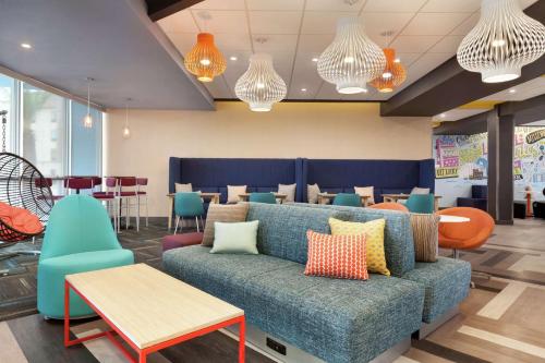 a living room with a couch and tables and chairs at Tru By Hilton Lake Charles in Lake Charles