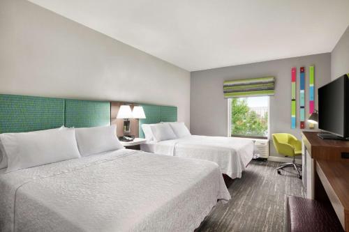 Cette chambre comprend 2 lits et une télévision à écran plat. dans l'établissement Hampton by Hilton Oklahoma City I-40 East- Tinker AFB, à Midwest City