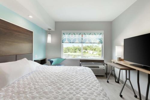 a bedroom with a bed and a desk and a television at Tru By Hilton Lake Charles in Lake Charles