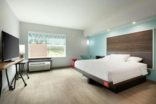 a bedroom with a bed and a desk and a television at Tru By Hilton Lake Charles in Lake Charles