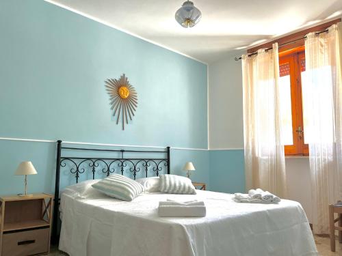 1 dormitorio con 1 cama con pared azul en Geko house, en Marina di Leuca