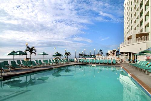 a swimming pool with chairs and a hotel at Hilton Suites Ocean City Oceanfront in Ocean City