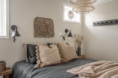 um quarto com uma cama com almofadas em Modern nybyggd lägenhet i Orsa Grönklitt em Orsa