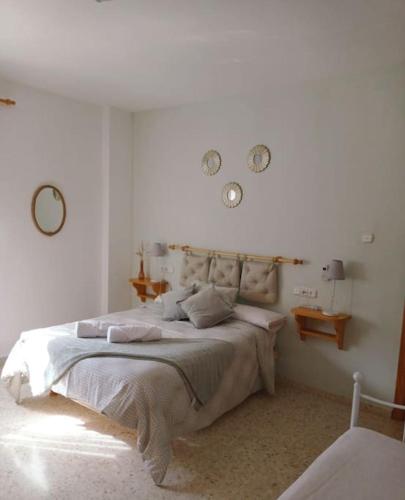 a bedroom with a large bed with two clocks on the wall at LabellaCasona in Quéntar