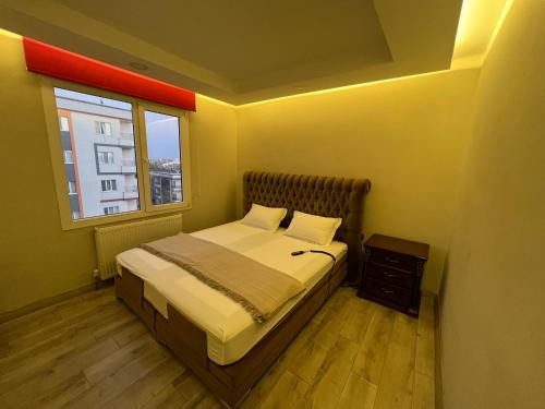 a small bedroom with a bed and a window at XANTHOS APART HOTEL Midyat Merkezde in Midyat
