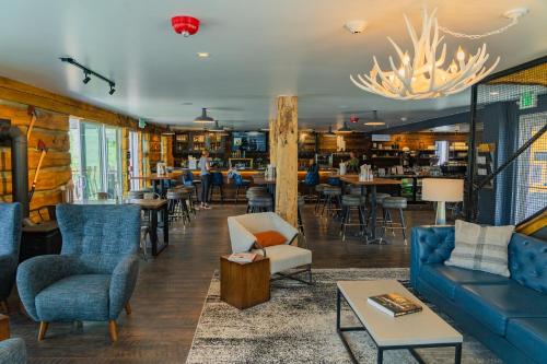 a living room with a couch and chairs and tables at Gravity Haus Winter Park in Winter Park