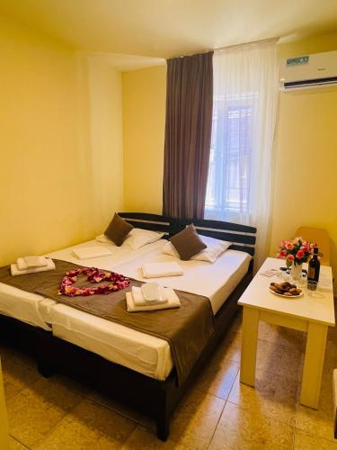 a bedroom with two beds and a window and a table at MarNar Hotel in Yerevan
