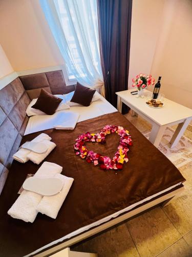 a room with a bed with a heart made out of flowers at MarNar Hotel in Yerevan