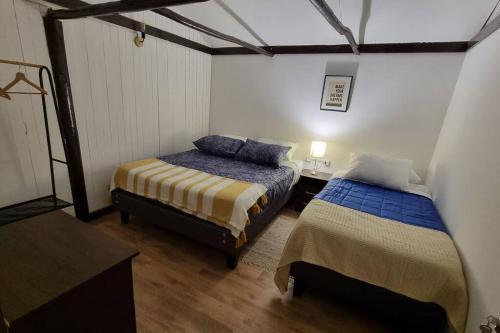 a bedroom with two beds in a room with a table at ¡Cabaña full equipada para 6! in Guayacán