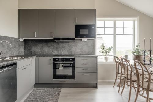 烏沙的住宿－Modern nybyggd lägenhet i Orsa Grönklitt，厨房配有不锈钢用具和木椅