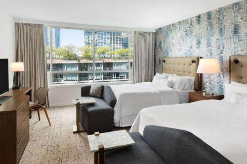 una camera d'albergo con due letti e un divano di Hilton Vancouver Downtown, BC, Canada a Vancouver