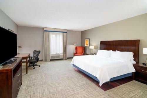 a hotel room with a bed and a flat screen tv at Hilton Garden Inn Augusta in Augusta