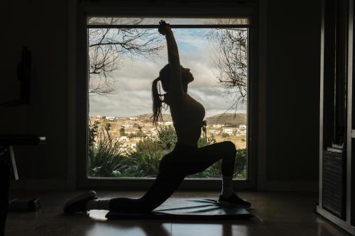 a woman doing a yoga pose in front of a window at Amaike Hotel Golf & Spa in Tandil