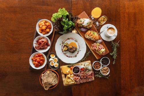 a table topped with plates of food and bowls of food at Amaike Hotel Golf & Spa in Tandil