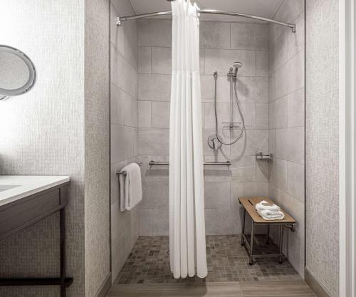 a bathroom with a shower with a shower curtain at Hilton Austin Airport in Austin