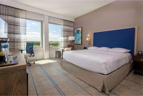a bedroom with a large bed and a large window at Hilton Austin Airport in Austin