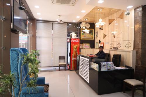 a woman sitting at a counter in a restaurant at Hotel Mittal Inn in Ajmer