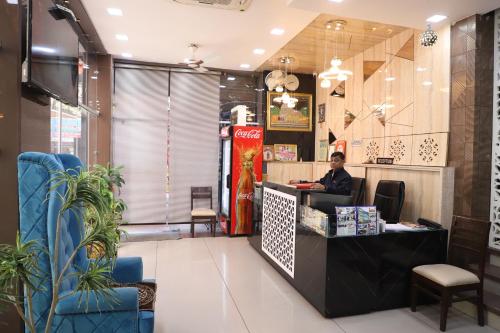 a man sitting at a counter in a restaurant at Hotel Mittal Inn in Ajmer