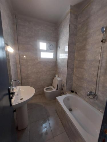 uma casa de banho com uma banheira, um WC e um lavatório. em La Perla Resort Ras Sudr em Ras Sedr