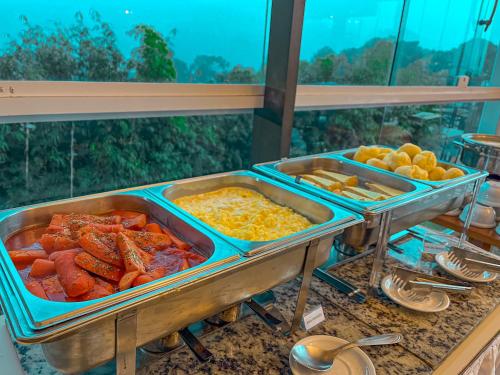 a buffet with many trays of food on a table at Hotel Dan Inn Campos do Jordão in Campos do Jordão