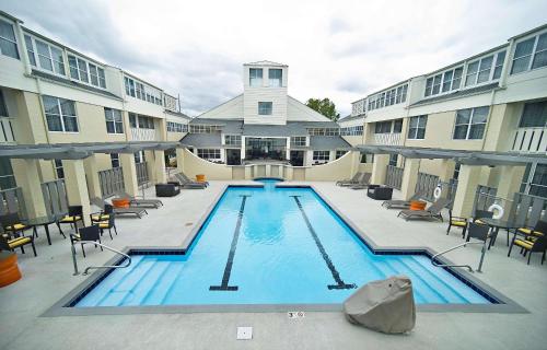 a large swimming pool with chairs and a building at DoubleTree by Hilton Huntsville-South in Huntsville