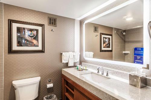 a bathroom with a sink and a toilet and a mirror at DoubleTree by Hilton Memphis in Memphis