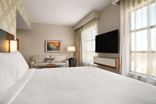 a hotel room with a bed and a flat screen tv at Embassy Suites by Hilton McAllen Convention Center in McAllen