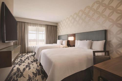 ein Hotelzimmer mit 2 Betten und einem TV in der Unterkunft Embassy Suites by Hilton McAllen Convention Center in McAllen