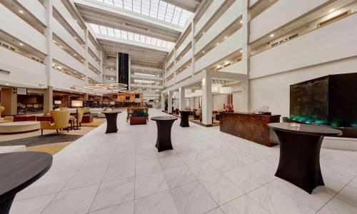 un vestíbulo con mesas y sillas en un edificio en Embassy Suites by Hilton Milwaukee Brookfield, en Brookfield