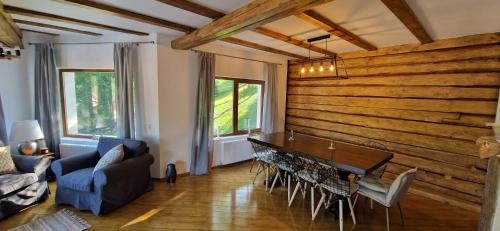 a living room with a wooden wall and a table at Chalet Poarta in Bran
