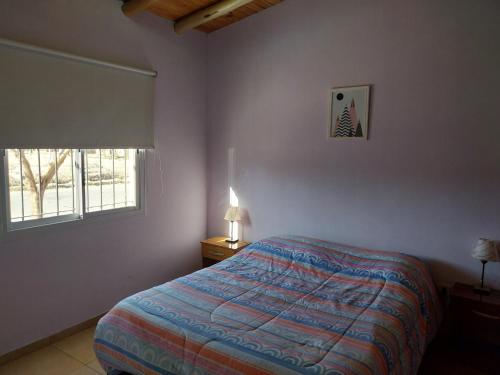 1 dormitorio con cama y ventana en Departamento Benielli en San Rafael