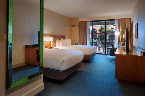 a hotel room with two beds and a balcony at DoubleTree by Hilton Newark-Fremont in Newark