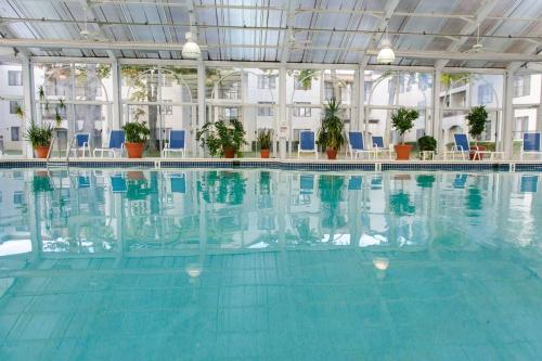 una gran piscina con sillas azules en un edificio en DoubleTree Suites by Hilton Mount Laurel, en Mount Laurel