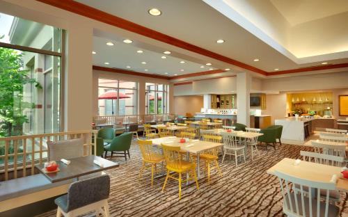 a restaurant with tables and chairs in a cafeteria at Hilton Garden Inn Salt Lake City/Sandy in Sandy