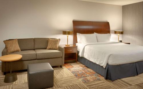 a hotel room with a bed and a couch at Hilton Garden Inn Salt Lake City/Sandy in Sandy